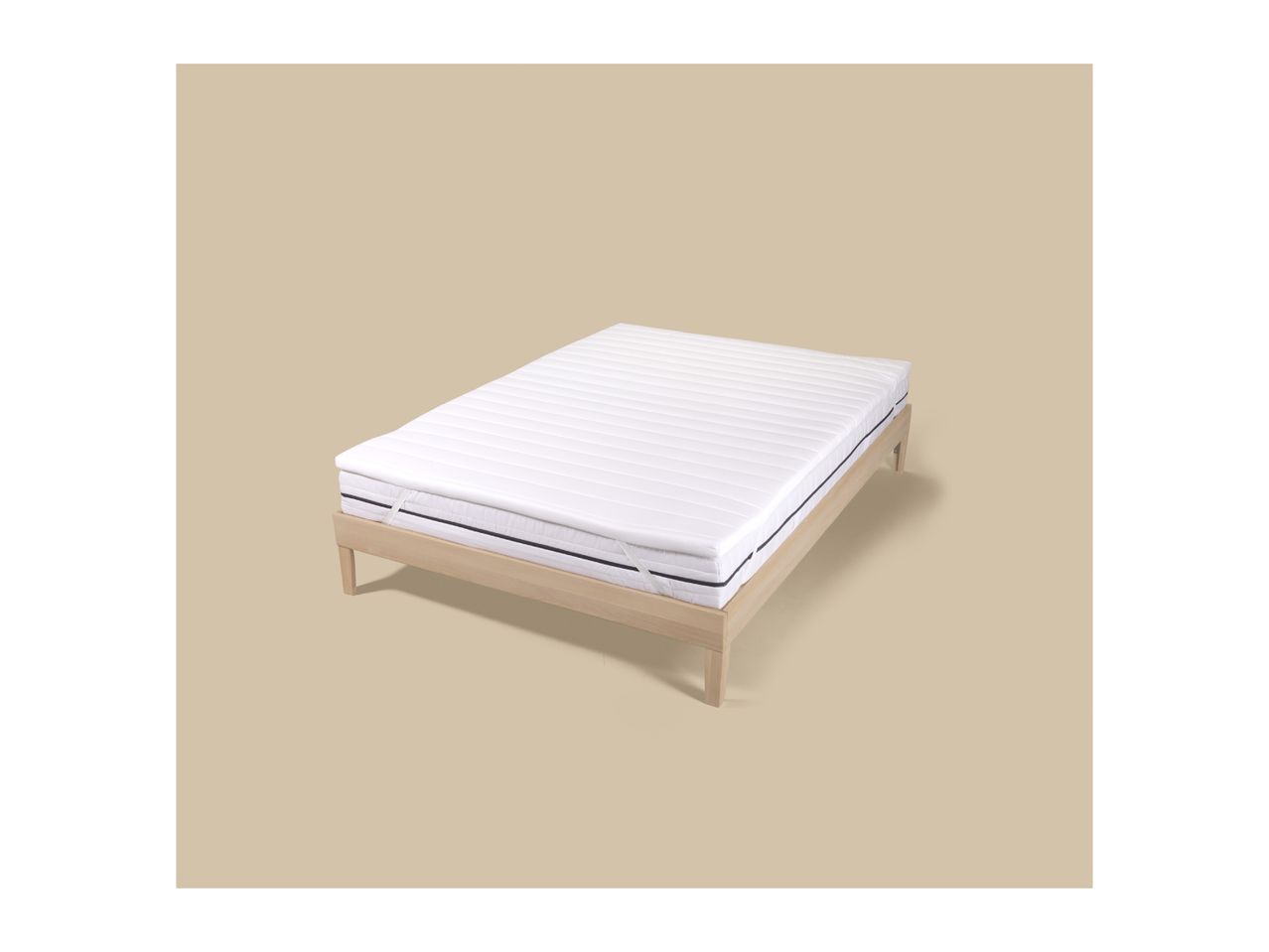 White mattress topper with elastic corner straps on a wooden bed frame