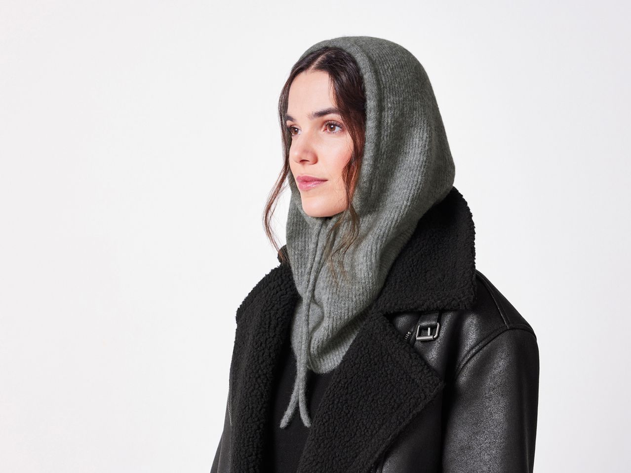 Woman in a grey knitted balaclava and a black faux leather jacket