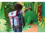 Criança com mochila num ambiente temático de selva, apontando para longe.