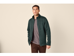 Man in een donkergroen fleecejack met rits en een bruine broek.