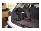 Car trunk with a tire inflator, jump starter, and storage box.