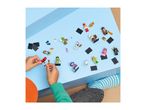 A child's hands playing with various toy figures and accessories on a blue surface.