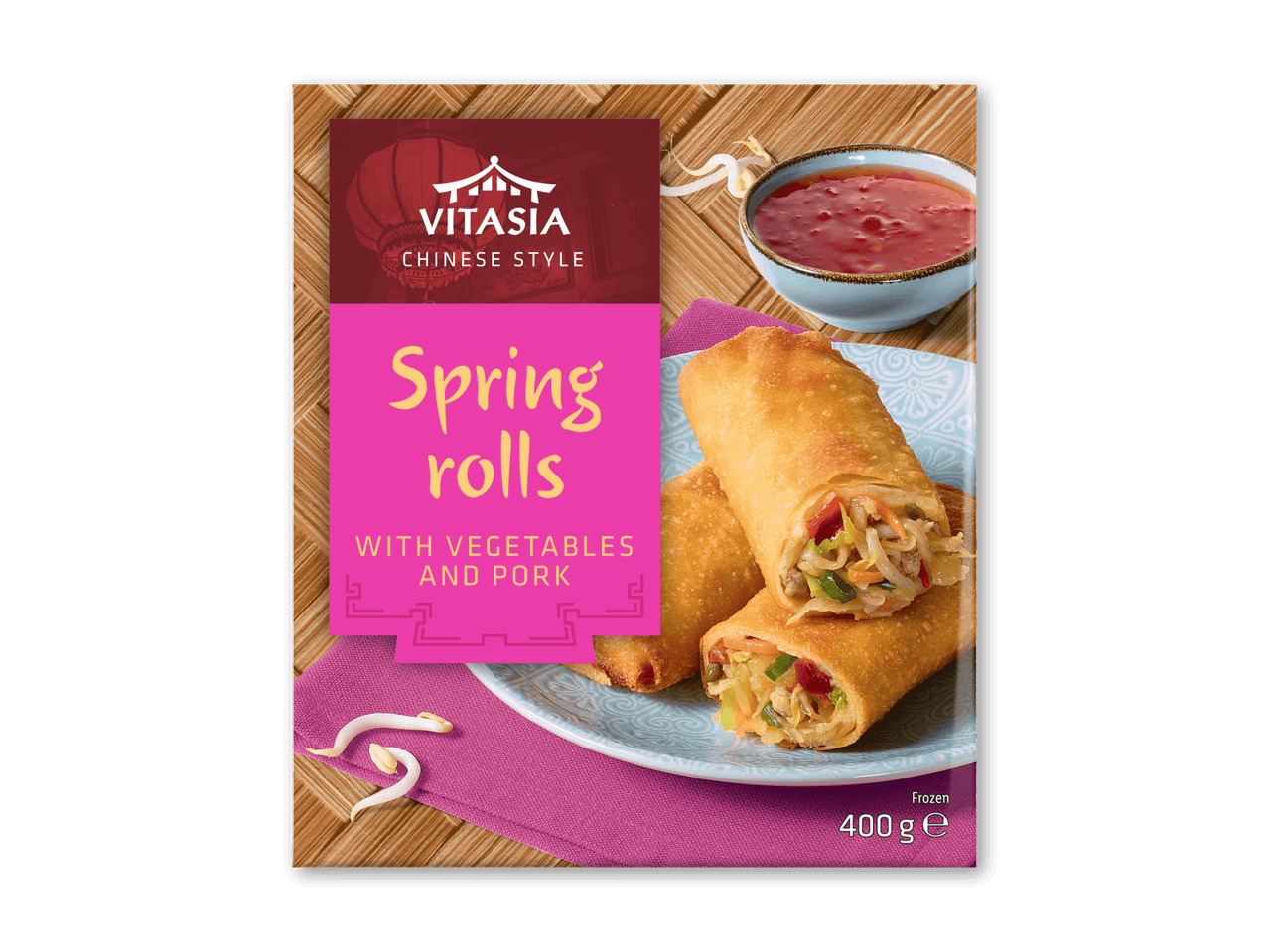 Frosne forårsruller med grøntsager og svinekød, serveret med chilisauce.