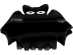 A black bat-shaped hair clip with white eyes.