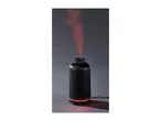 Black ribbed aroma diffuser emitting red-lit mist against a dark background