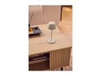 A modern grey cordless table lamp on a wooden coffee table.