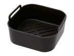 Black silicone air fryer basket with handles and a ridged bottom.