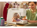 Woman sewing with a LIVARNO home sewing machine, focused on her craft.