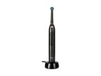 A black electric toothbrush with a blue and green brush head, standing on a charging base.