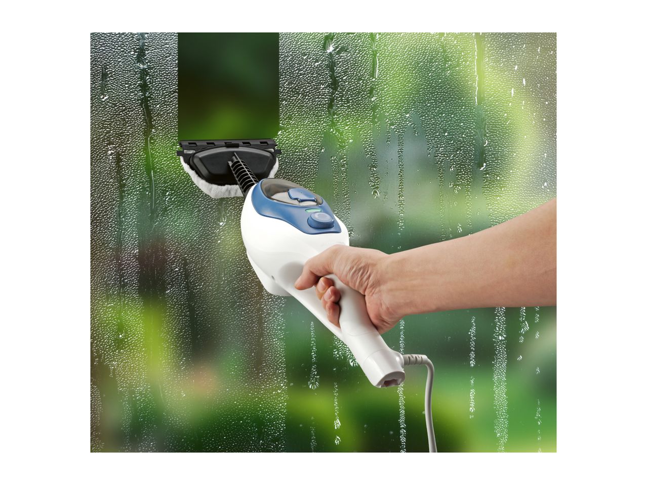 Hand holding a window cleaner, cleaning a steamy window with a green background.