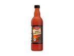 En flaske sød chilisauce med en sort etiket, der viser et solnedgangslandskab.