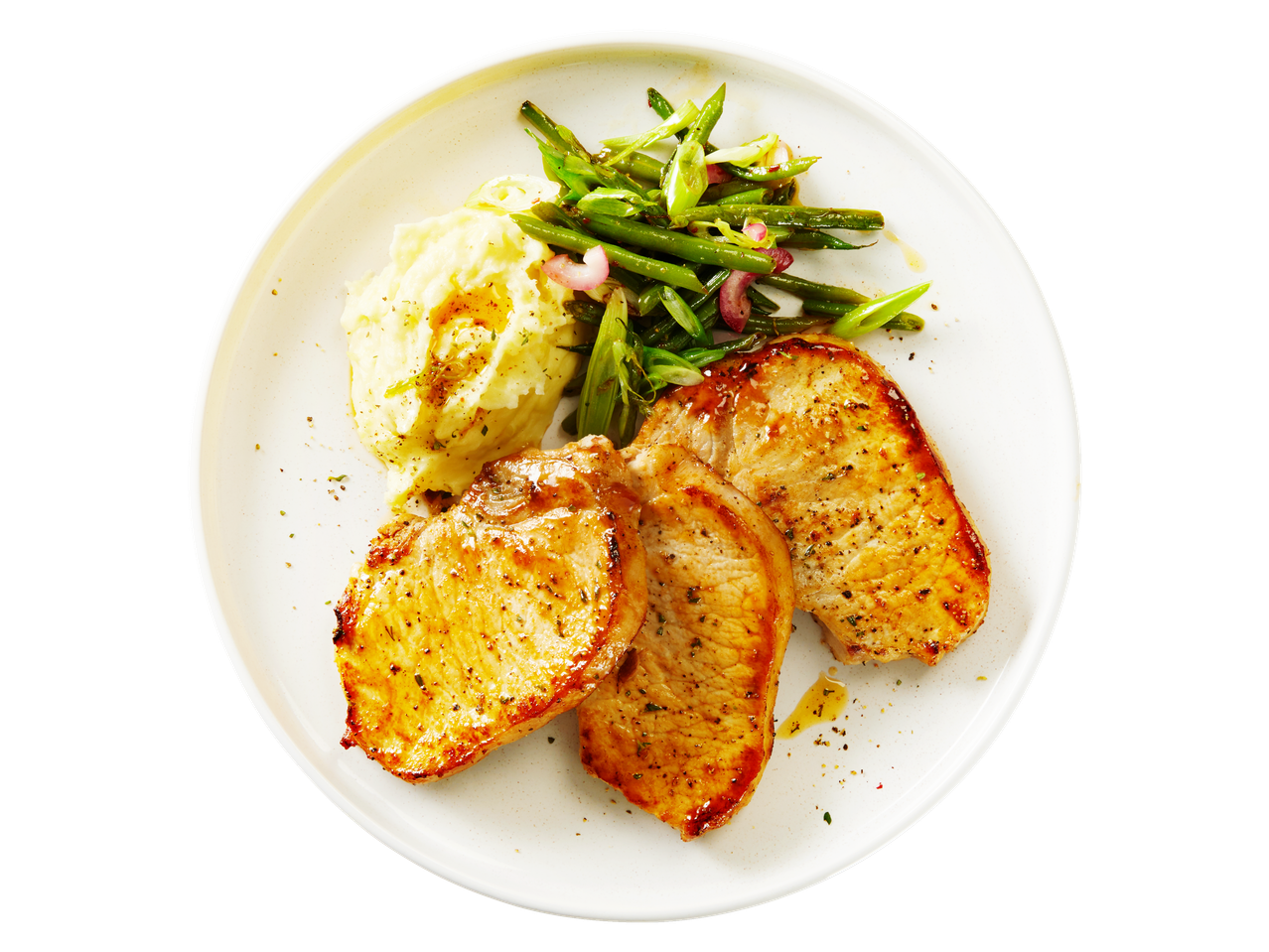 Pork chops with mashed potatoes and green beans on a white plate.