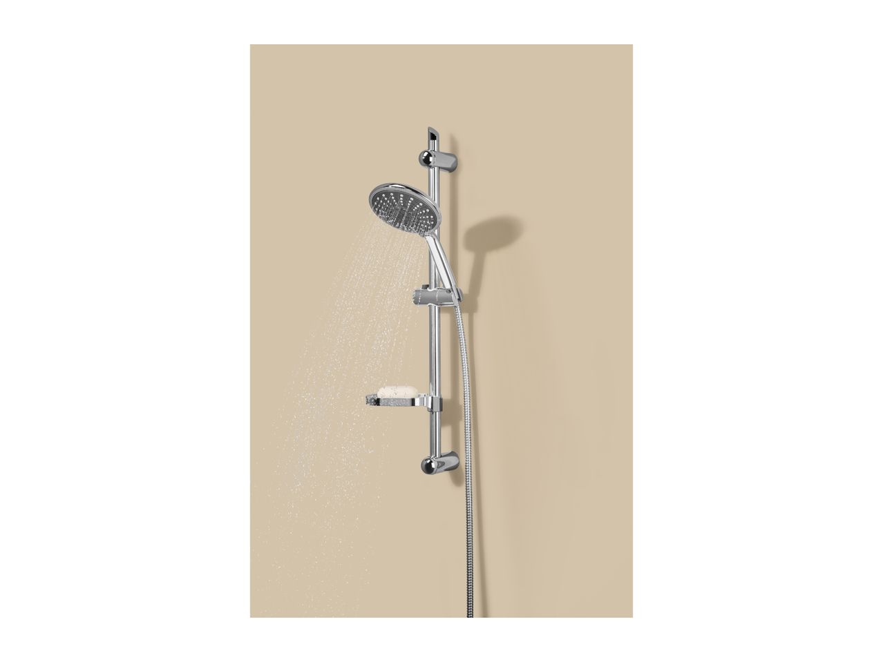 Chrome shower set with a handheld showerhead spraying water, mounted on a beige wall.