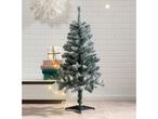 Flocked artificial Christmas tree with gifts and string lights in a festive setting.