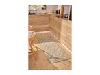 Geometric patterned kitchen runner rug on a light wood floor in a modern kitchen.