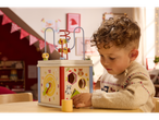 Bambino che gioca con una scatola attività in legno con labirinto di perline.
