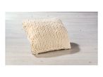 A cream-colored chunky knit blanket or throw pillow on a light wooden surface.