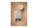 Kitchen scale and a bowl of flour on a wooden surface.