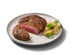 Steak de bœuf grillé avec une tranche coupée, accompagné d'une salade fraîche.