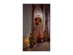 Two small Christmas trees and a wreath with warm LED lights, set against a rustic wooden door.