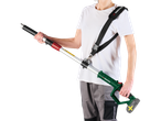 Man holding a battery-powered telescopic hedge trimmer with a PARKSIDE shoulder strap.