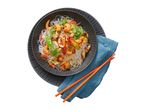 Glass noodle stir-fry with prawns, mushrooms, and vegetables, served in a dark bowl with chopsticks.