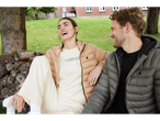Two people in U.S. Grand Polo puffer jackets and casual wear, laughing outdoors.