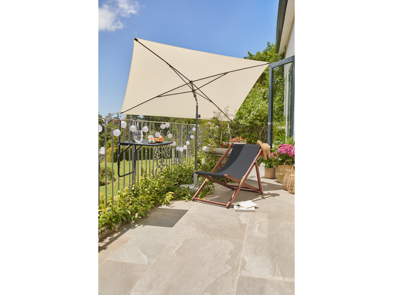 Livarno Sonnenschirm σε μπαλκόνι με ξαπλώστρα και τραπέζι.