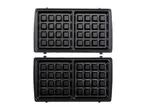 Open waffle maker with two sets of square waffle plates, top view.