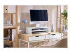 Home office desk with a computer, monitor stand, blue lamp, and wooden shelving unit.
