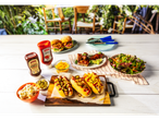 A summer BBQ feast featuring Batt's ketchup and BBQ sauce, hot dogs, pulled pork sliders, ribs, and salad.