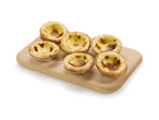 Six tartes Pastel de Nata sur une planche en bois