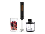 Hand blender with a measuring cup of berries and a food chopper attachment.