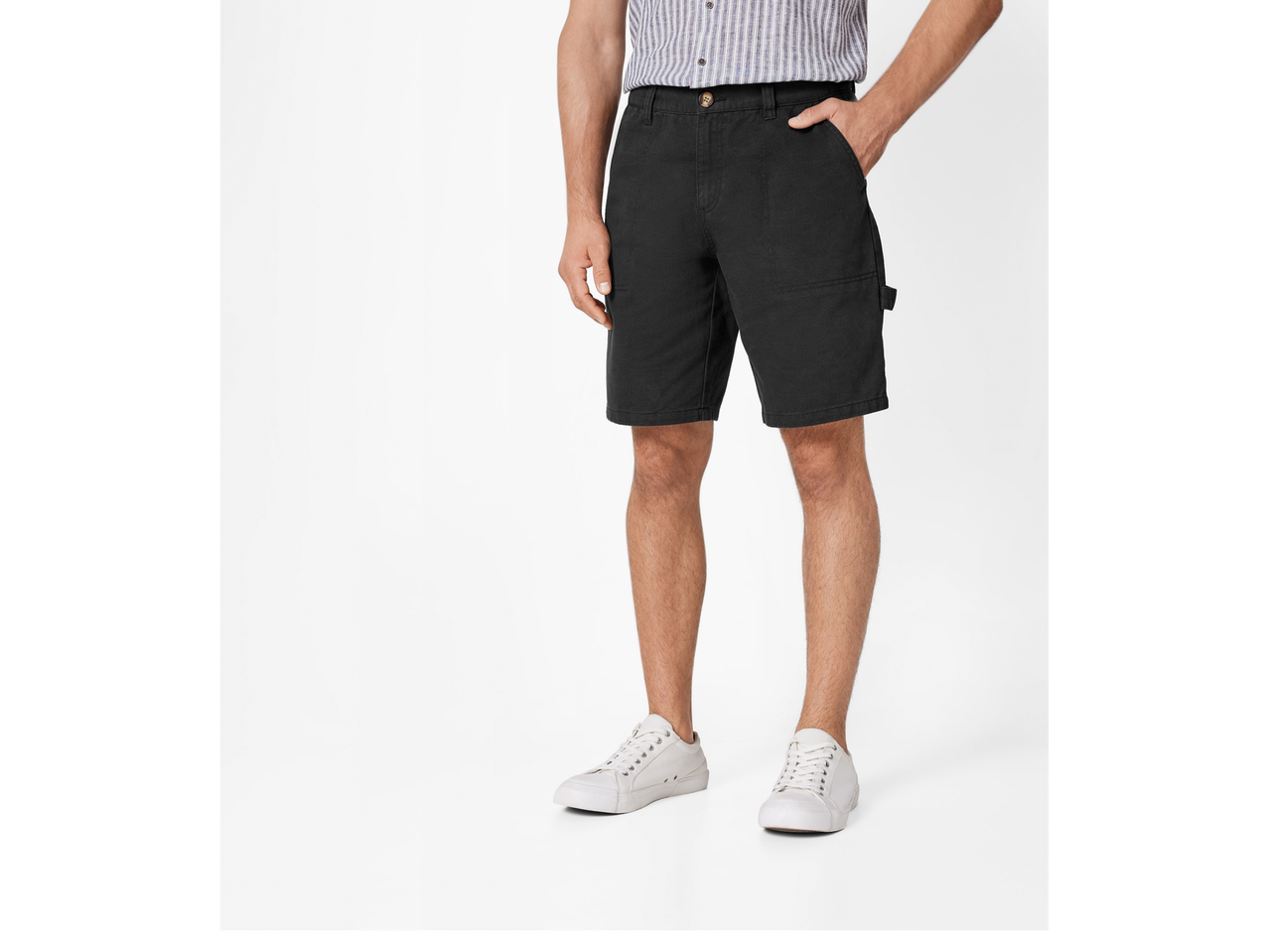 Bărbat îmbrăcat în pantaloni scurți de lucru negri și adidași albi.