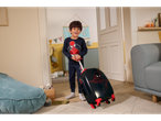 Smiling boy in Spiderman tracksuit with Spiderman suitcase in a child's room