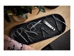 Manicure set with nail clippers, cuticle nippers, and scissors on a black marble tray.
