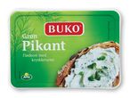 Buko Grøn Pikant flødeost med krydderurter på et stykke brød.