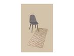A modern grey chair next to a beige patterned runner rug.