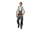 Man in gray work overalls and a white t-shirt, smiling at the camera.