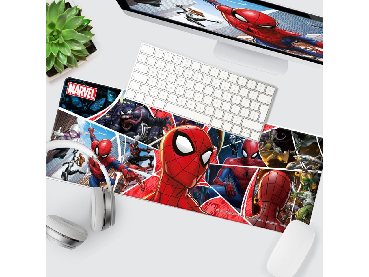 A desk mat featuring various comic book characters, with a keyboard, headphones, and mouse.