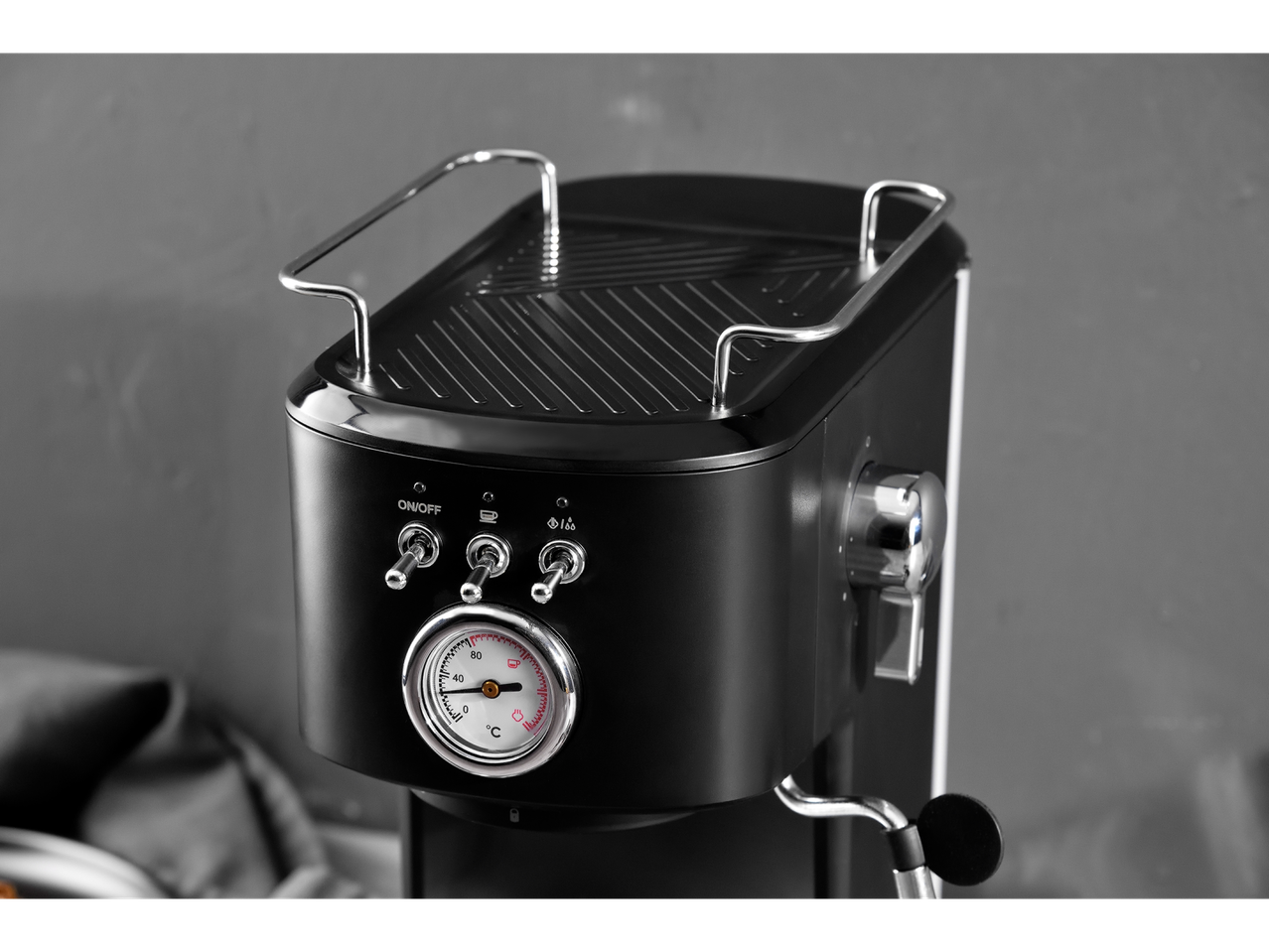 Black espresso machine with thermometer and controls.