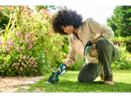 A person uses a Parkside grass trimmer in a garden.