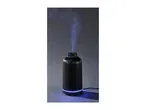 Black ribbed ultrasonic aroma diffuser emitting a blue-lit mist against a dark background