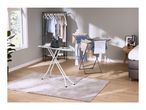 An ironing board with an iron and a clothes drying rack in a modern bedroom.