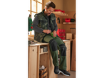 Man in PARKSIDE PERFORMANCE® work trousers and vest, sitting on a workbench.