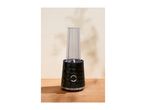 A black personal blender with a clear plastic bottle on a wooden table.