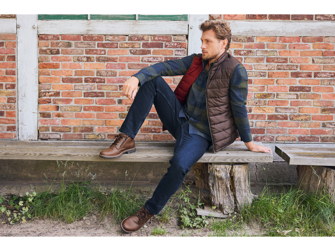 Man wearing Esmara men's winter boots, jeans, plaid shirt, and a vest, sitting on a bench.