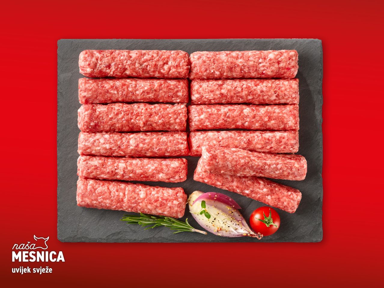 Naša Mesnica: Svježe ćevapi na crnoj ploči s rajčicom i lukom.