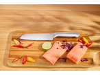 Due filetti di salmone, peperoncini, lime e un coltello Silvercrest su un tagliere di legno.