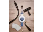 A steam cleaner with various attachments, including brushes, nozzles, a measuring cup, and a cloth.